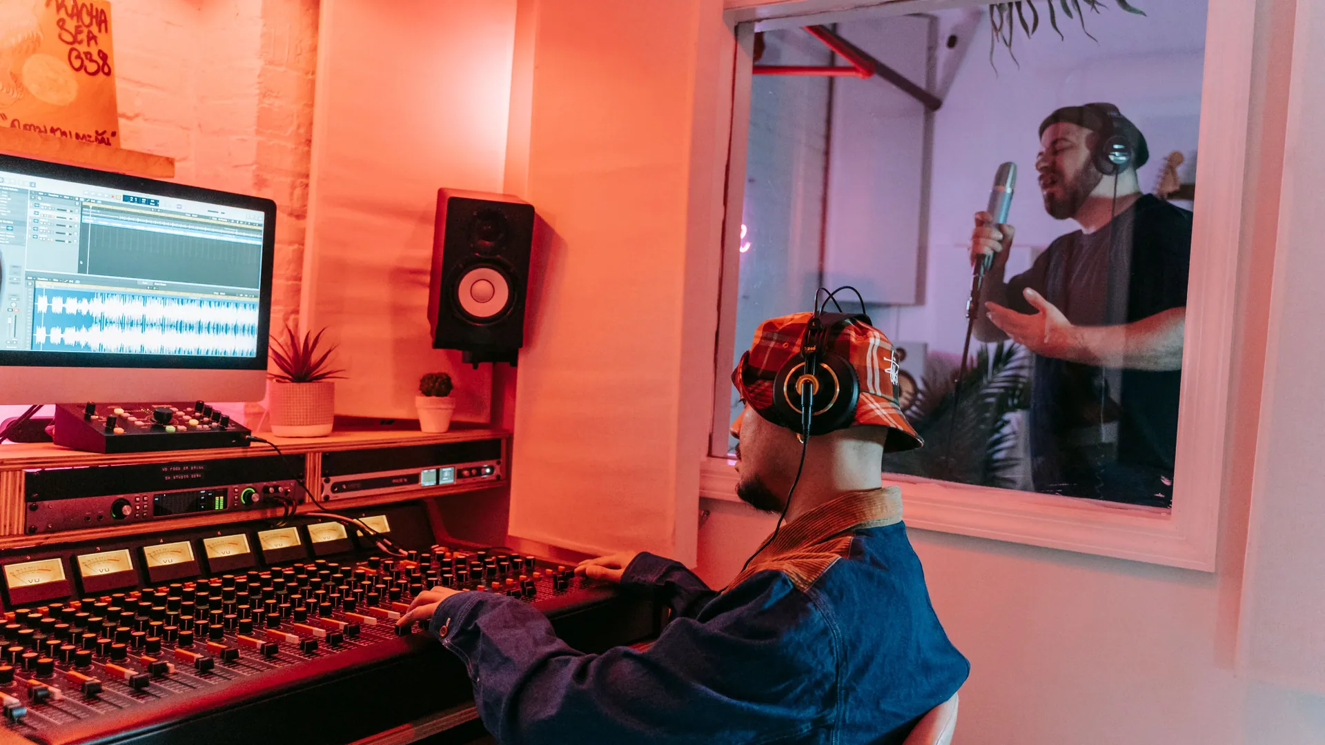 Productor y cantante trabajando durante una sesión en un estudio de grabación